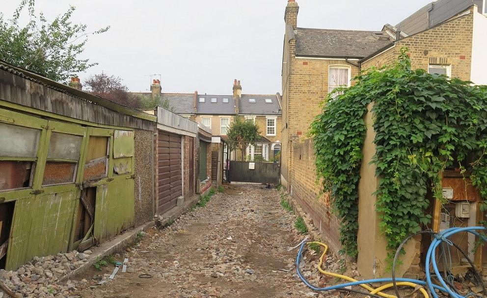image of the length of a garden with soil and rubble on the ground