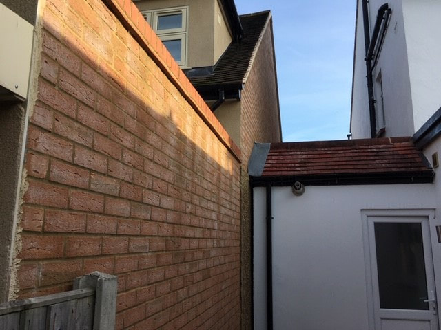 Image of a neighbours extension up to the boundary wall. Antino and Associates can assess this under the Party Wall Act.